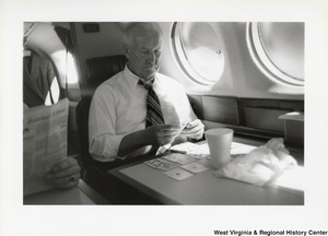 Governor Arch Moore playing cards by himself on an airplane.