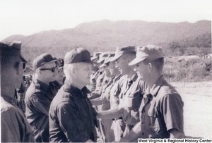 Governor Arch Moore shaking the hand of a solider. Other unidentified men are with the Governor and shaking the hands of other soldiers.