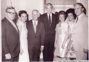 Governor Arch Moore (third from left) and his wife, Shelley, (third from right) standing with three unidentified men and two unidentified women.