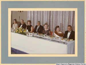 Shelley Moore (third from the left) eating with an unidentified group of men and women.