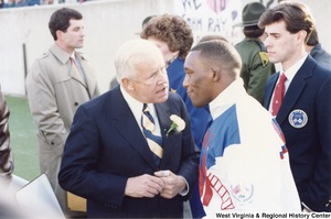 Governor Arch Moore speaking to Olympic wrestler Nate Carr. Standing beside them is Olympic sport shooter Webster Wright.