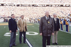 Four unidentified men standing on the WVU football field during a ceremony for 1988 Olympic athletes Nate Carr and Webster Wright.