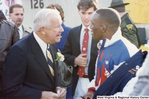Governor Arch Moore speaking to Olympic athlete Nate Carr. Olympic athlete Webster Web Wright is standing between them.
