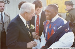 Governor Arch Moore speaking to Olympic athlete Nate Carr. Olympic athlete Webster Web Wright is standing between them.
