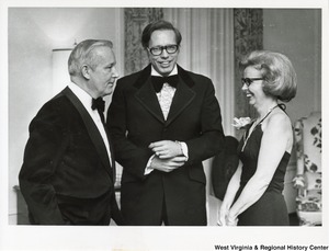 Governor Arch Moore (left) speaking to an unidentified man and woman.