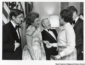 Governor Arch Moore (third from right) with his wife Shelley (second from right) at a party. Two unidentified men and one woman are talking to them.