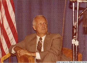 Arch Moore sitting in a chair on the stage during his campaign rally for governor.