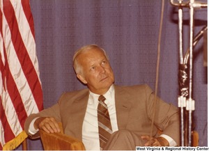 Arch Moore sitting in a chair on the stage during his campaign rally for governor.