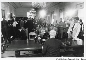 Governor Arch Moore speaking to the press. The photo is taken from behind the Governor so you can see the press filming and recording the speech.