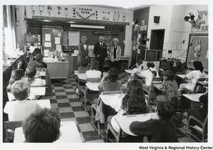 Governor Arch Moore and his wife, Shelley, standing with an unidentified teacher in front of a class of children.