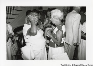 Two unidentified women speaking during a party.