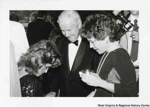 Governor Arch Moore speaking with two unidentified women at a party.