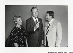 Vice President George H. W. Bush (center) with an unidentified man and woman. Bush is pointing towards the right.
