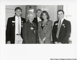 Shelley Moore (second from left) with three unidentified men and one woman. They are all wearing campaign buttons for the 1988 election. The campaign buttons say Bush Quayle 88, Arch Moore, Moore for Governor, and Nelson Robinson for State Auditor.