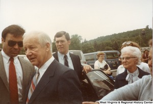 Governor Arch Moore being surrounded by people after he exits a vehicle.