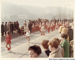 An unidentified high school marching band during Governor Arch Moores inaugural parade in Charleston. The band is wearing red uniforms with white accents. The majorettes are wearing white dresses with red accents. All uniforms have a red P on the chest.