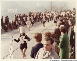 An unidentified high school marching band during Governor Arch Moores inaugural parade in Charleston. The band and majorettes are wearing black, white, and red uniforms with a K on the chest.
