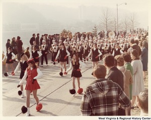 An unidentified high school marching band during Governor Arch Moores inaugural parade in Charleston. The band and majorettes are wearing black and white uniforms with a symbol of a knights head on the chest.