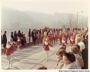 An unidentified high school marching band during Governor Arch Moores inaugural parade in Charleston. The band and majorettes are wearing red and white uniforms.