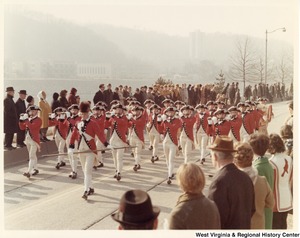 The Fife and Drum Corps from the Army Third Infantry playing at Governor Arch Moores inaugural parade. They are wearing red and white uniforms with black accents.