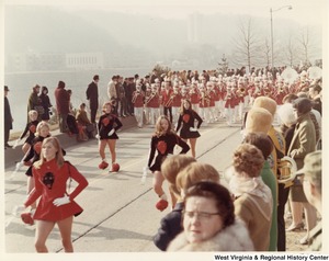 The Calhoun County High School at during Governor Arch Moores inaugural parade in Charleston. The band is wearing red and white uniforms. The majorettes are wearing black dresses with a red devil on the chest. One majorette is wearing a red dress with a black devil on the chest.